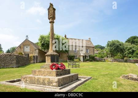 Le village green et souvenir Croix dans le village de Cotswold Guiting Power, Gloucestershire, England, UK Banque D'Images