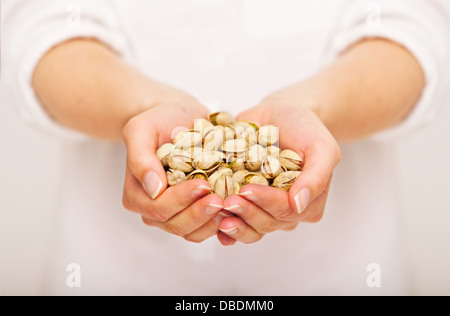 Femme offrant une poignée de pistaches Banque D'Images