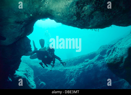 Approches de scuba diver l'entrée d'une grotte sous-marine dans le Nord de la Floride. Banque D'Images