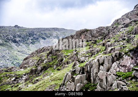 SNOWDONIA, pays de Galles — les montagnes escarpées du nord du parc national de Snowdonia vues le long de la route A4086. Cet itinéraire pittoresque offre des vues spectaculaires sur la campagne galloise, avec ses sommets imposants, ses paysages rocheux et ses vallées étendues, ce qui en fait un trajet populaire pour les passionnés de nature qui explorent le parc. Banque D'Images