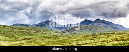 Parc national de Snowdonia Montagnes Pays de Galles | PARC NATIONAL DE SNOWDONIA, Pays de Galles — La crête sommitale déchiquetée de Yr Wyddfa (Snowdon) s’élève au-dessus de la lande ouverte près de Capel Curig, vue depuis l’A4086 dans le parc national d’Eryri. Avec 3 560 pieds (1 085 m), c’est le plus haut sommet du Pays de Galles et des îles britanniques au sud des Highlands écossaises, sa silhouette façonnée par un ancien volcanisme et une érosion glaciaire ultérieure. Banque D'Images