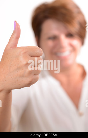 Woman giving a Thumbs up sign and smiling Banque D'Images
