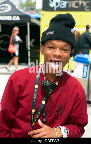 Adolescent tirant sa langue de façon ludique au photographe. Banque D'Images