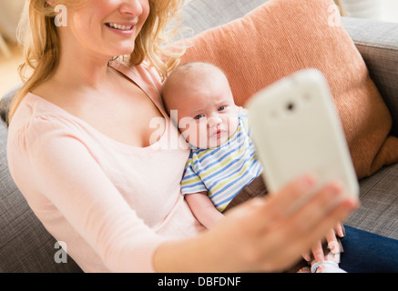 Caucasian mother taking photo d'elle-même et le bébé Banque D'Images