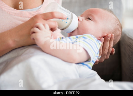 Caucasian mother bottle feeding baby Banque D'Images