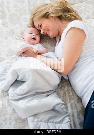 Caucasian mother and baby laying on bed Banque D'Images