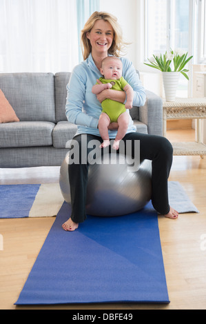 Caucasian mother holding baby on exercise ball Banque D'Images
