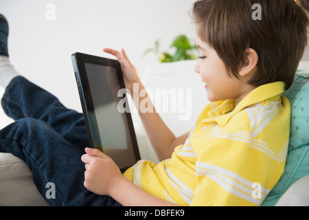 Hispanic boy using tablet computer Banque D'Images