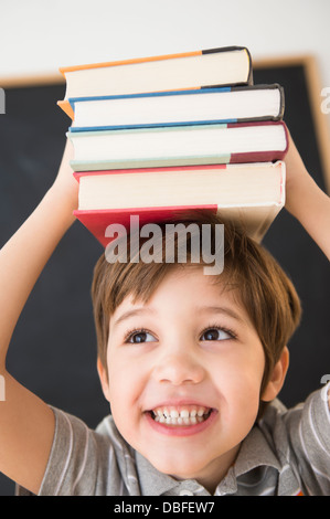 Woman balancing books on head Banque D'Images