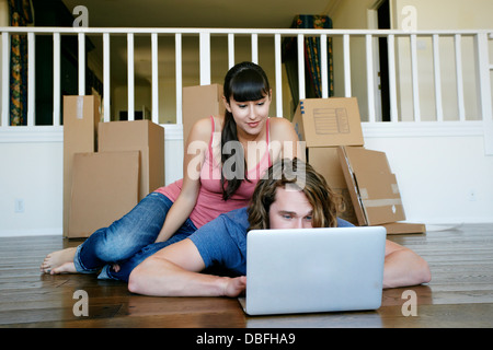 Couple using laptop in new home Banque D'Images