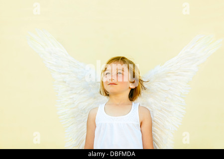 Smiling girl wearing angel wings Banque D'Images