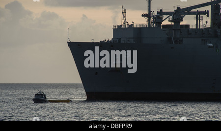 Un canot pneumatique à coque rigide (RHIB) à partir de la station d'amphibie Navire de débarquement USS Pearl Harbor (LSD 52) Remorque une l'équipage du bateau de pêche, fait à partir de la mer à bord de la commande de transport maritime de marchandises militaires et munitions ship USNS Matthew Perry (T-AKO-9), à l'autre o Banque D'Images