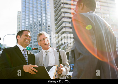 Businessmen talking on city street Banque D'Images