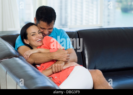 Beautiful Black Couple Cuddling On Couch At Home, Watching Tv