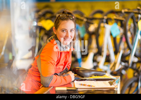 Caucasian woman smiling in Bicycle shop Banque D'Images