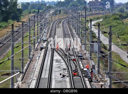 Les travailleurs des chemins de réparer la ligne de chemin de fer à grande vitesse de la glace qui a été inondée au cours de l'Elbe les inondations près de Schoenhausen, Allemagne, 30 juillet 2013. Le ministre allemand des transports La Société veut obtenir un aperçu de l'avancement de la réparation après la ligne a été inondé en juin. Photo : JAN WOITAS Banque D'Images