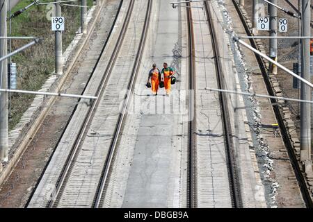 Les travailleurs des chemins de réparer la ligne de chemin de fer à grande vitesse de la glace qui a été inondée au cours de l'Elbe les inondations près de Schoenhausen, Allemagne, 30 juillet 2013. Le ministre allemand des transports La Société veut obtenir un aperçu de l'avancement de la réparation après la ligne a été inondé en juin. Photo : JAN WOITAS Banque D'Images