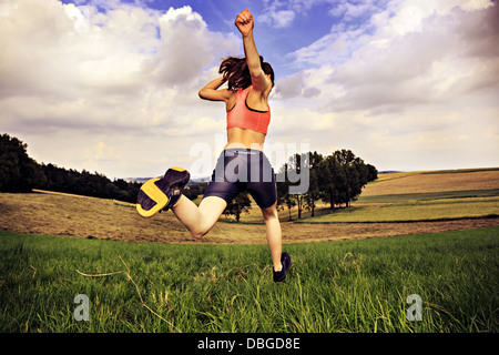 Jeune femme jogging en face de cross country Banque D'Images