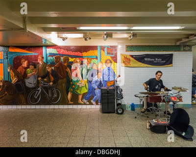 Rue Busker interprète dans le métro de New York à côté d'une grande mosaïque Banque D'Images