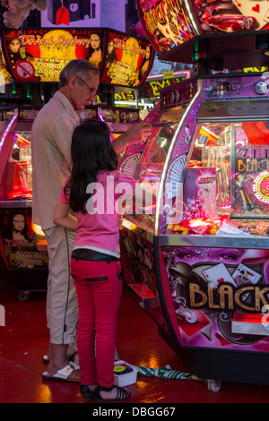 Avec Père fille jouant avec coin pusher / médaille push jeu Dans Jeux électroniques à voyager fête foraine et voyager fun fair Banque D'Images