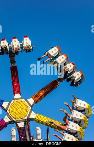 Thrillseekers excité / sensations fortes s'amusant sur fairground attraction G Force à voyager fête foraine et voyager fun fair Banque D'Images