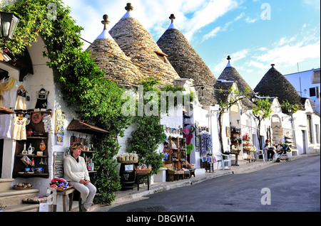 Maisons traditionnelles à toit conique trulli utilisées aujourd'hui comme boutiques de cadeaux dans le joli village touristique blanchi à la chaux d'Alberobello, Apulia, Italie Banque D'Images