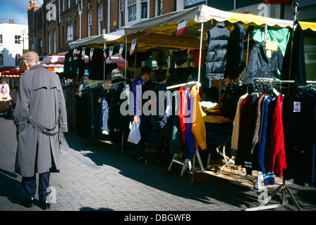 Marché français Sutton High Street Surrey homme âgé marcher par des vêtements Stall Banque D'Images