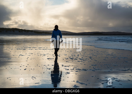 Femme marche sur la plage de Traigh Hornais, North Uist, Hébrides extérieures, en Écosse Banque D'Images