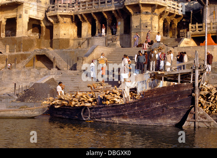 Varanasi Inde Gange brûlant Ghats et bateau transportant le bois Banque D'Images