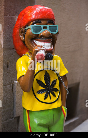 La figure d'un Rasta fumer un joint dans une ruelle dans le Barri Gòtic, Barcelone, Espagne Banque D'Images