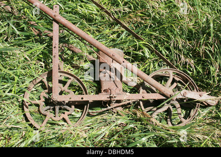 Un semoir maïs couché dans l'herbe sur une ferme à Altona, Manitoba, Canada Banque D'Images