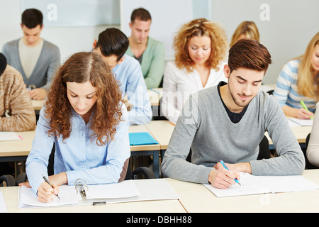 De nombreux étudiants en conférence à l'université prendre des notes en classe Banque D'Images