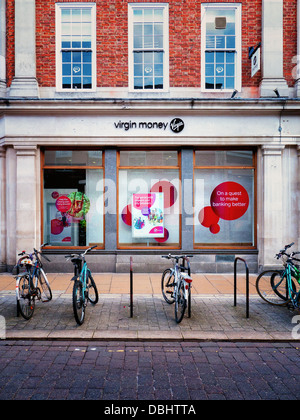 Pushbikes sur supports à vélo sur un trottoir trottoir devant la boutique Virgin Money à York, au Royaume-Uni. Concept bancaire britannique. Banque D'Images