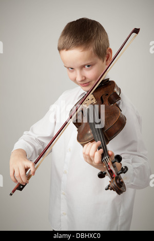 Adolescent à jouer du violon, fond gris Banque D'Images