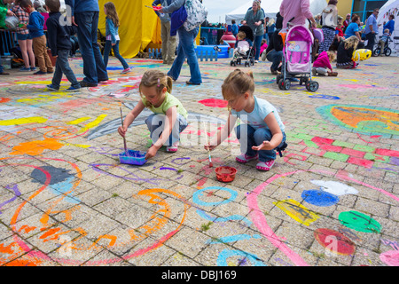 Deux jeunes filles faisant la peinture à l'étage de la semaine Poisson Pembrokeshire festival à Milford Haven. Banque D'Images