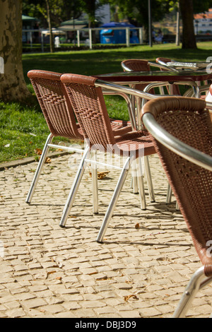 Chaises métalliques de couleur du vin dans une esplanade avec vue sur le jardin Banque D'Images