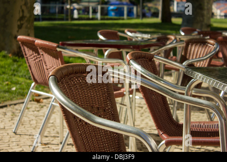 Chaises métalliques de couleur du vin dans une esplanade avec vue sur le jardin Banque D'Images