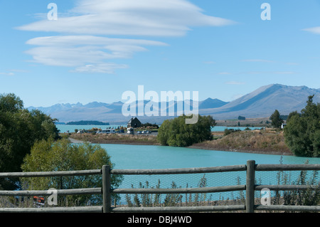 Lake Tekapo, Nouvelle-Zélande, du barrage du lac Barrière, montrant, à l'église du Bon Pasteur, et les montagnes brumeuses avec ciel bleu Banque D'Images