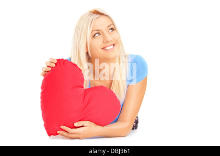 Female couché avec coeur rouge dans ses mains et me demande, isolé sur fond blanc Banque D'Images