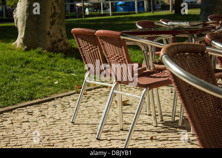 Chaises métalliques de couleur du vin dans une esplanade avec vue sur le jardin Banque D'Images