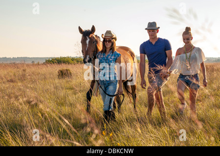 La Croatie, Dalmatie, jeunes gens à cheval de marcher à travers la prairie Banque D'Images