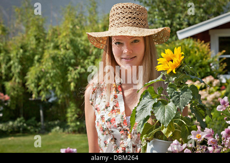 Mid adult woman with Straw Hat dans le jardin, Munich, Bavière, Allemagne Banque D'Images
