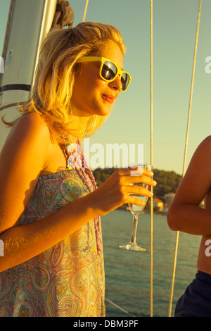 En Croatie, Mer Adriatique, young woman drinking champagne on boat Banque D'Images