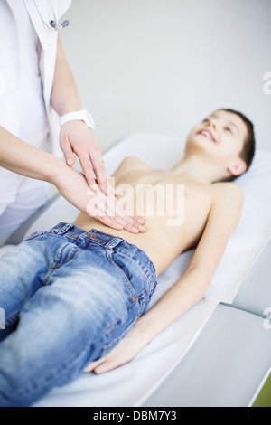 Femme médecin l'examen de l'abdomen du garçon, Osijek, Croatie Banque D'Images