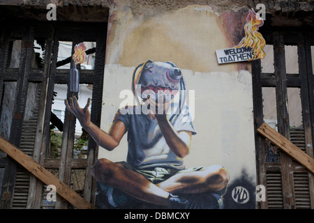 Graffiti dans Exarcheia quartier commerçant d''Athènes dépeint un émeutiers tenant un cocktail Molotov. Banque D'Images