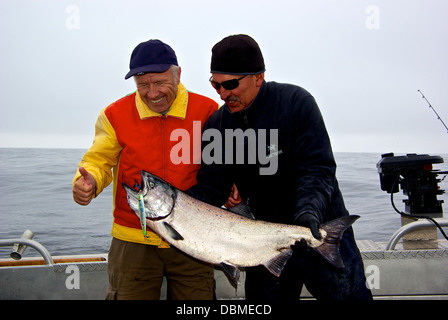 Guide de pêche pêcheur Happy smiling holding big sport pris le saumon quinnat de Swiftsure BC Banque D'Images