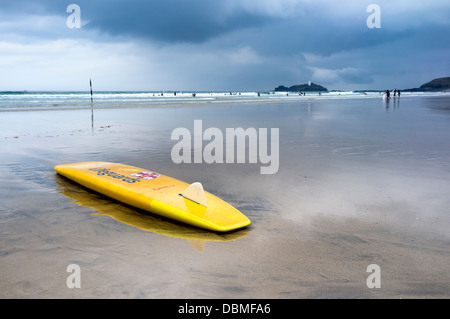 Les sauveteurs RNLI surf board sur Gwithian Beach, North Cornwall. Les surfeurs sont dans la mer derrière. Photo par Julie Edwards Banque D'Images