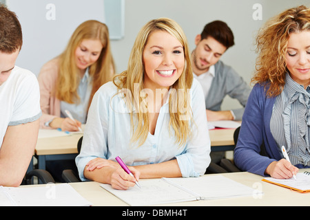 Heureux les étudiants prise de notes en classe d'une université Banque D'Images