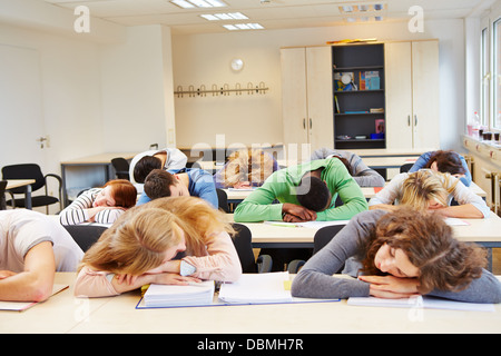 De nombreux étudiants fatigués de dormir dans classe avec leurs têtes sur la table Banque D'Images