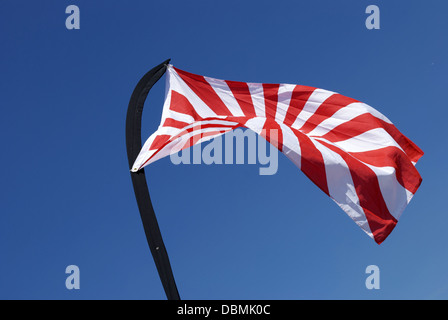 Soleil levant drapeaux dans le vent on blue sky Banque D'Images